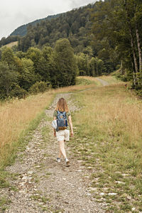 Rear view of woman walking on field