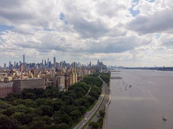 Aerial view of buildings in city against cloudy sky