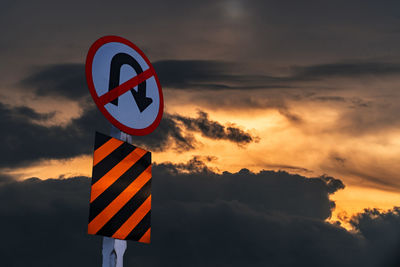 Information sign against sky during sunset