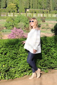 Portrait of woman standing against plants