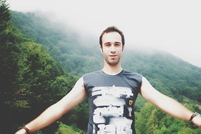 Portrait of young man standing on mountain