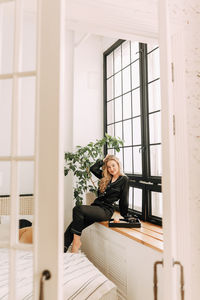 Portrait of woman sitting by window at home