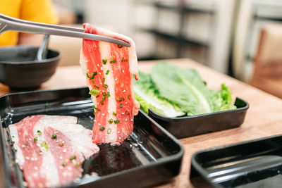 A rare slice of a5 saga wagyu with high marble texture season with chopped scallion and sesame.