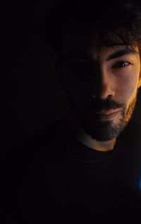 Portrait of young man against black background