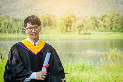 Portrait of smiling young man in graduation gown