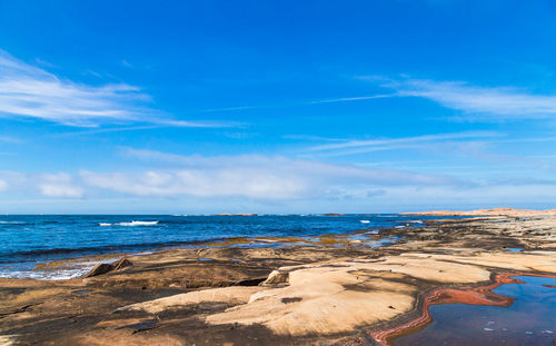 Scenic view of beach against blue sky