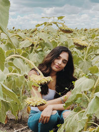 Portrait of young woman sitting on field