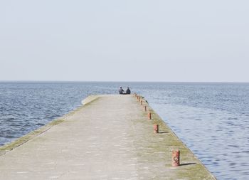 People on sea against clear sky