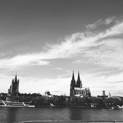 Churches in city by rhine river against sky