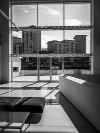 Modern buildings against sky seen through glass window