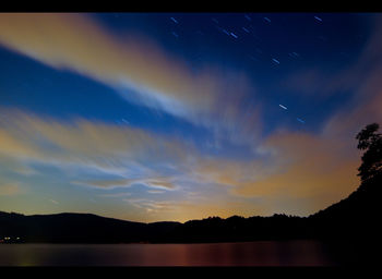 Scenic view of silhouette mountains against sky at night