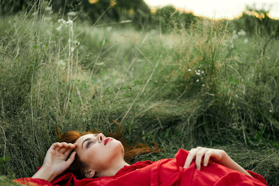 Woman lying on grassy field