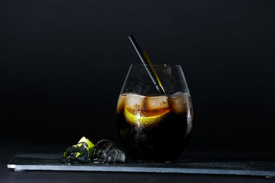 Close-up of glass on table against black background