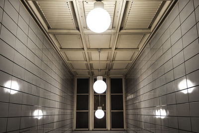 Low angle view of illuminated pendant lights hanging from ceiling