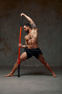 Man exercising with combat stick in gym