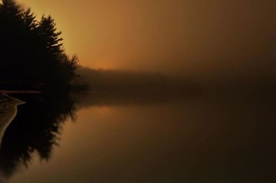 Scenic view of calm lake at sunset