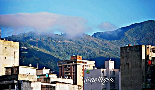 Houses in town against cloudy sky