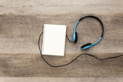 High angle view of headphones with book on table