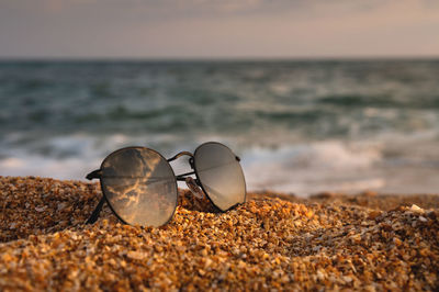 Close-up of sunglasses on beach