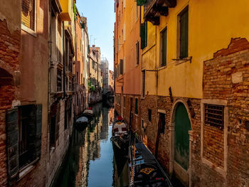 Boats in canal amidst buildings in city