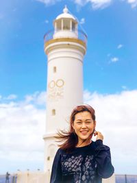 Portrait of smiling young woman against blue sky