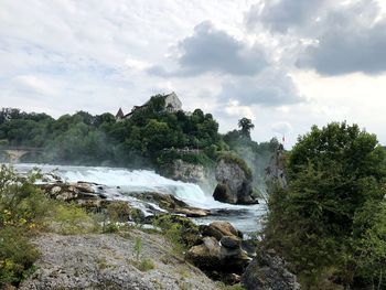 Scenic view of waterfall against sky