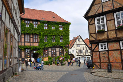 People on street amidst buildings in city