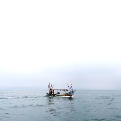 People in boat on sea against sky