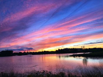 Scenic view of lake against romantic sky at sunset