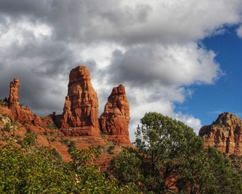 Low angle view of rock formations against cloudy sky