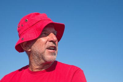 Portrait of man against red blue sky