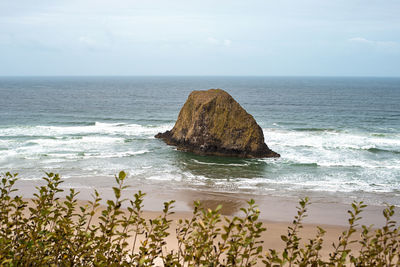 Scenic view of rocks in sea against sky