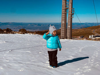 Rear view of woman standing on snow covered landscape