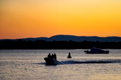 Silhouette boats in sea against clear sky