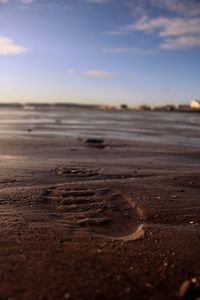 Surface level of sandy beach against sky