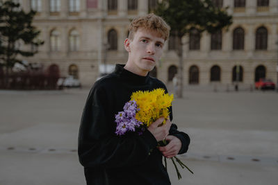Portrait of young woman holding bouquet
