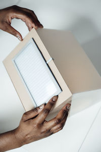 Hands of architect holding solar panel model at desk