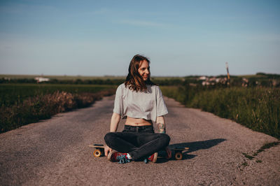 Young woman sitting on road