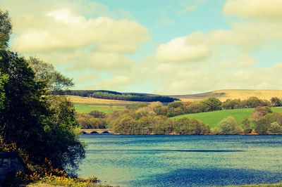 Scenic view of lake against cloudy sky