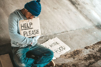 Midsection of man sitting on street