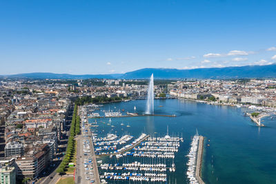 High angle view of city by sea against blue sky