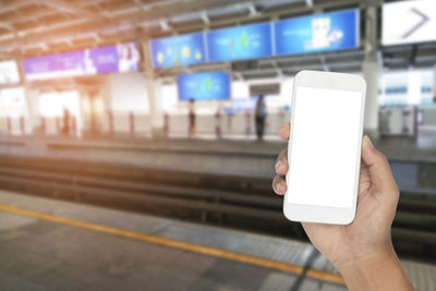 Man using mobile phone at railroad station