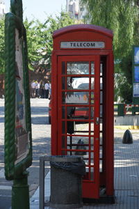 Red telephone booth against trees
