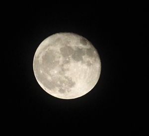 Low angle view of full moon against clear sky at night