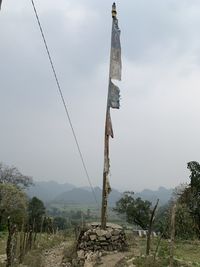 View of cross on landscape against sky