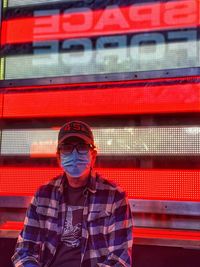 Portrait of man standing against red wall