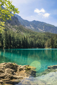 Scenic view of lake by mountains against sky