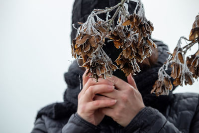 Close-up of hand holding dry leaf during winter