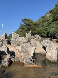 Rocks on shore against clear sky