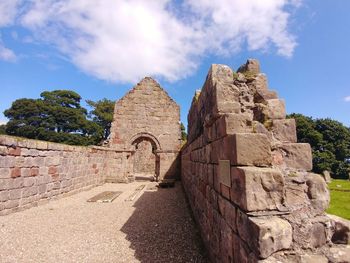 Low angle view of old ruin building against cloudy sky